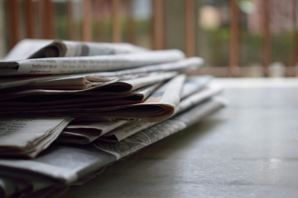 A stack of newspapers resting on a desk
